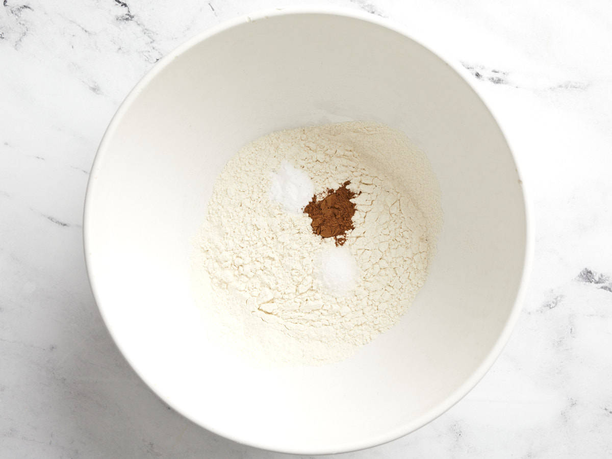 Flour, cinnamon and dry ingredients added to a bowl.