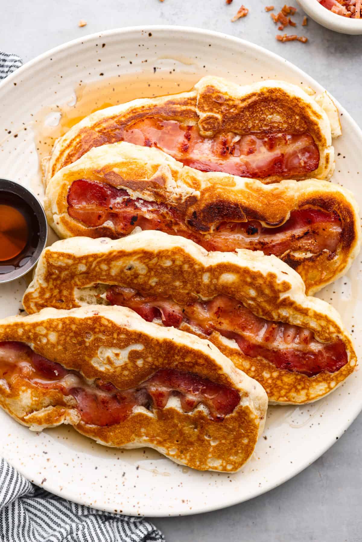 4 bacon pancakes on a plate.