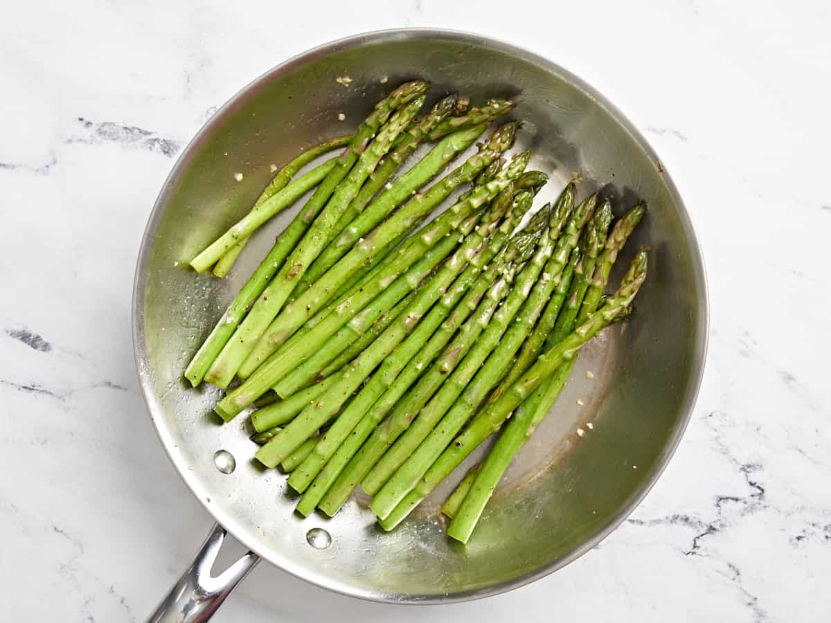 sauteed asparagus in a frying pan.