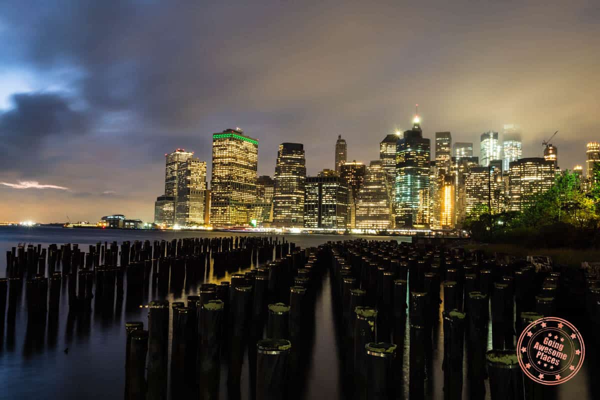 new york skyline lit up at night across the bay
