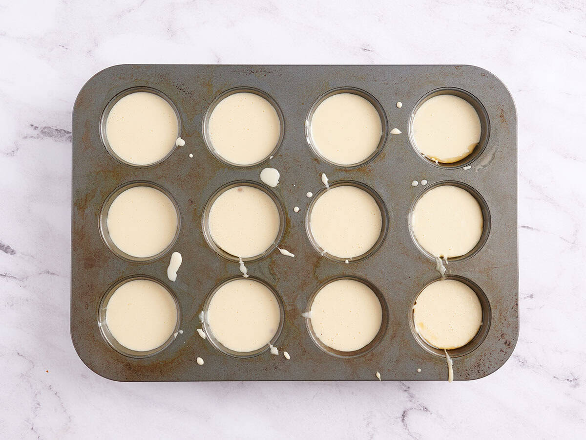 Raw popover batter in a muffin tray.
