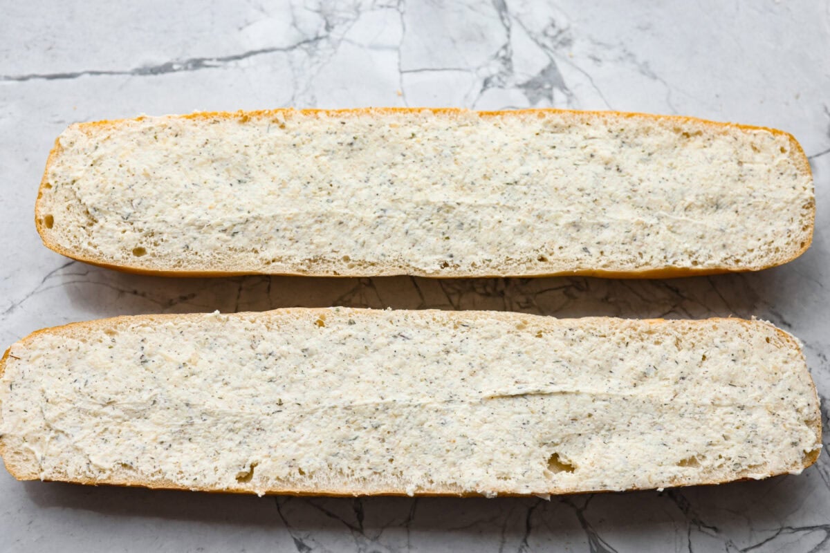 Garlic butter mixture spread over the halved French bread.