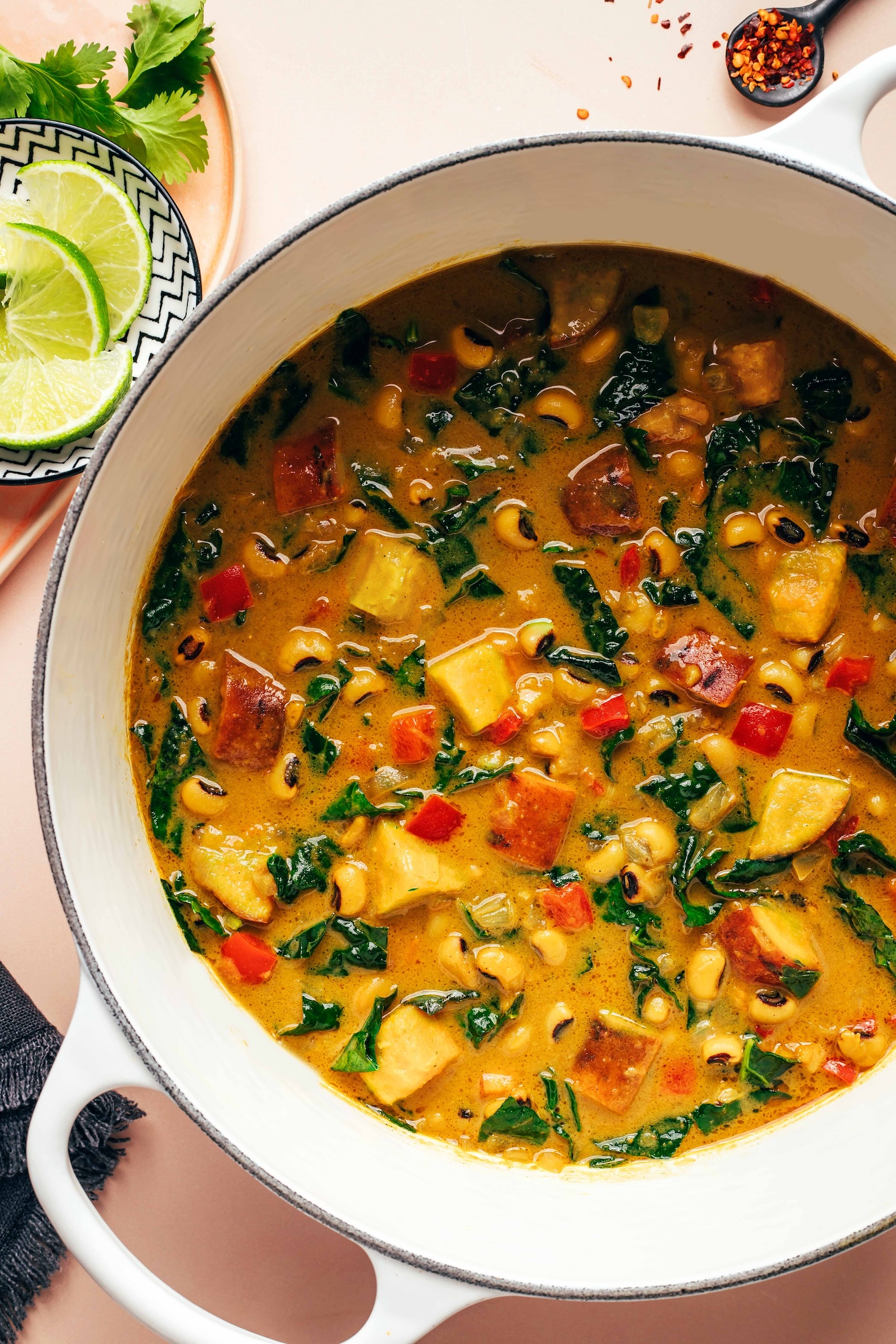 Lime slices next to a pot of creamy curried black eyed pea soup