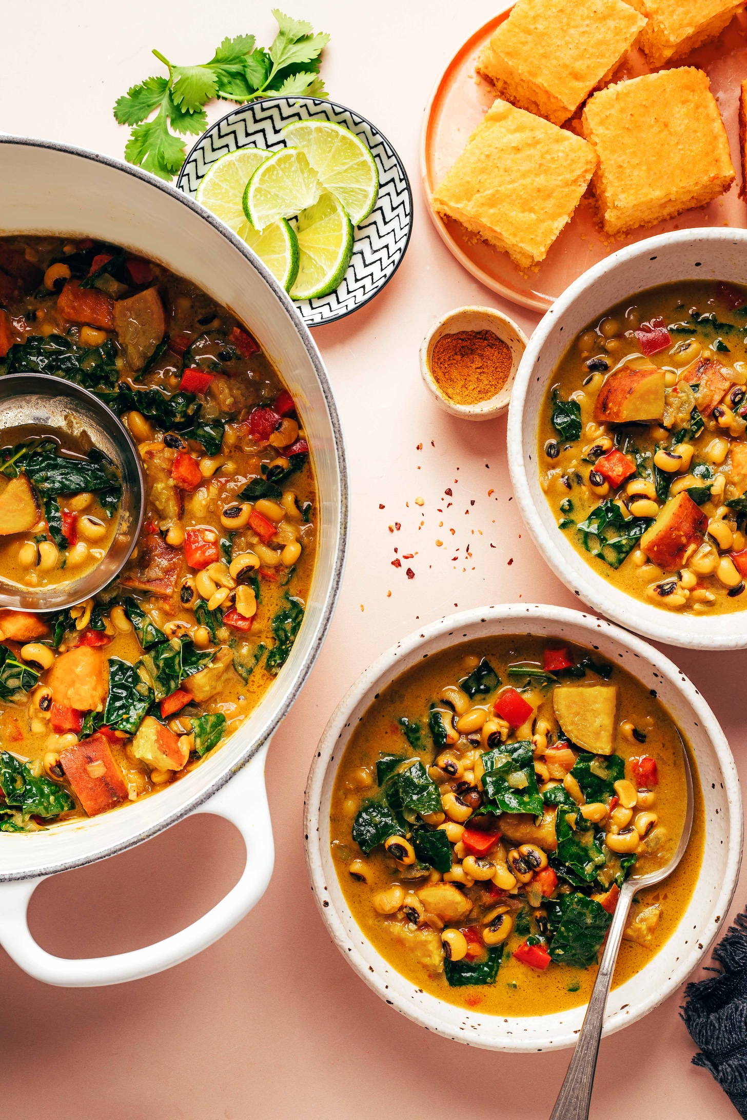 A Dutch oven and two bowls of our creamy curried black eyed pea soup recipe