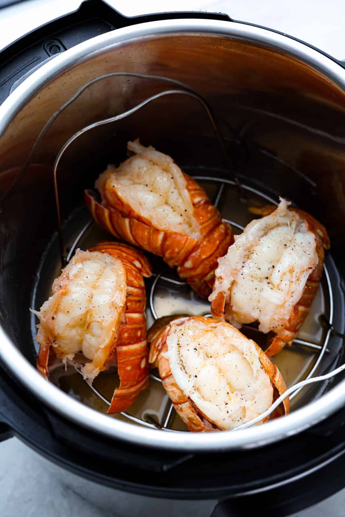 Instant pot lobster is the easiest way to bring a little luxury to your dinner table, no boiling pots or fancy techniques needed! In just minutes, the lobster cooks up tender, juicy, and perfectly steamed, ready to soak up a rich garlic-herb butter. Overhead shot of instant pot lobster tails inside the instant pot.