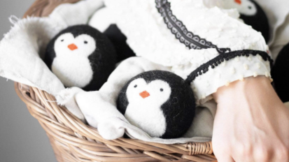 Wool dryer balls with penguin design in laundry basket