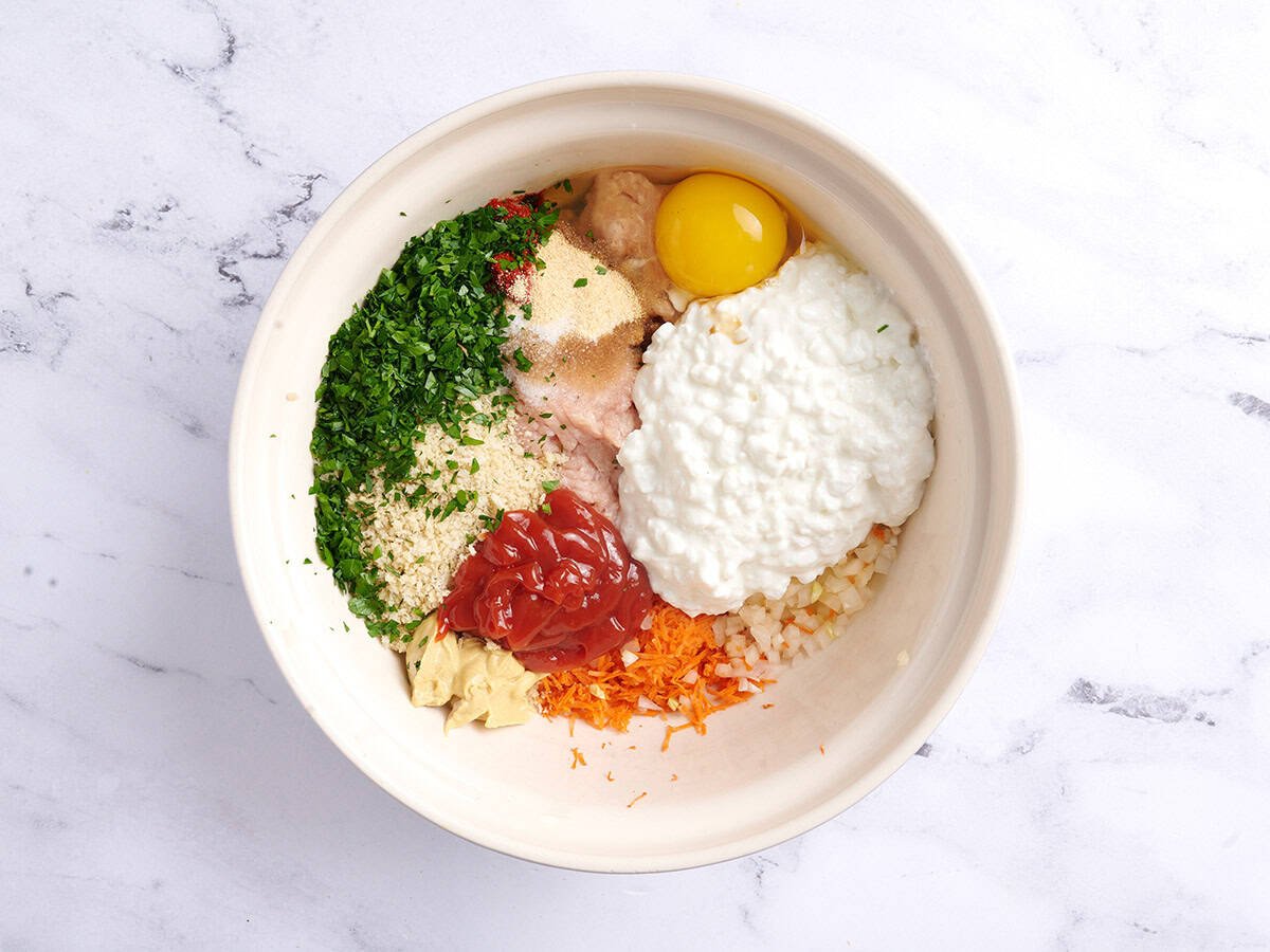 Ingredients to make chicken meatloaf in a white bowl.