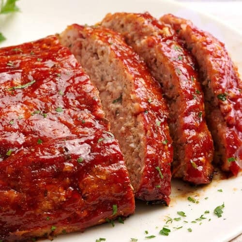 Chicken meat loaf on a platter with a few slices cut.