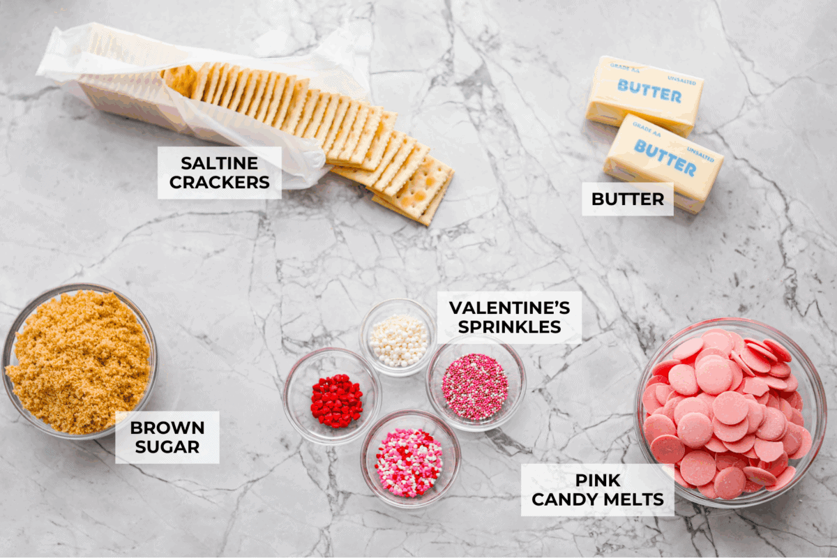My Valentine’s Day Crack is the cutesy pink version of my famous Christmas crack! Same buttery, snappy toffee base, just with pink candy melts and festive sprinkles. It's perfect for kids' parties, Galentine's, or a sweet little Valentine's treat. Overhead shot of labeled ingredients.