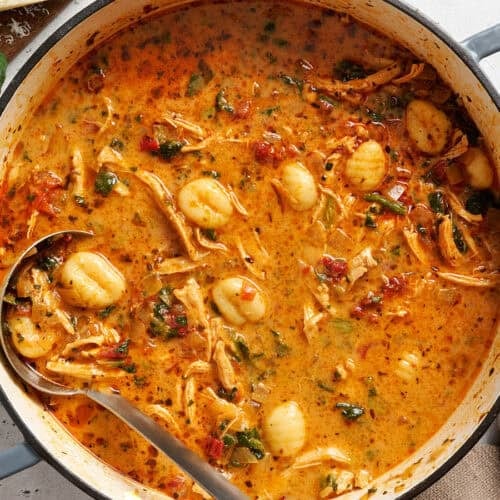 Pot of marry me chicken soup with a ladle in it.