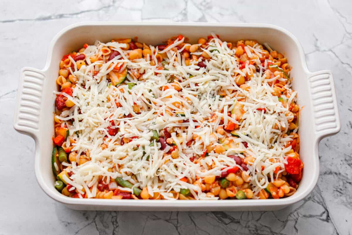 All of the ingredients mixed together and spread out in a casserole dish and topped with cheese.