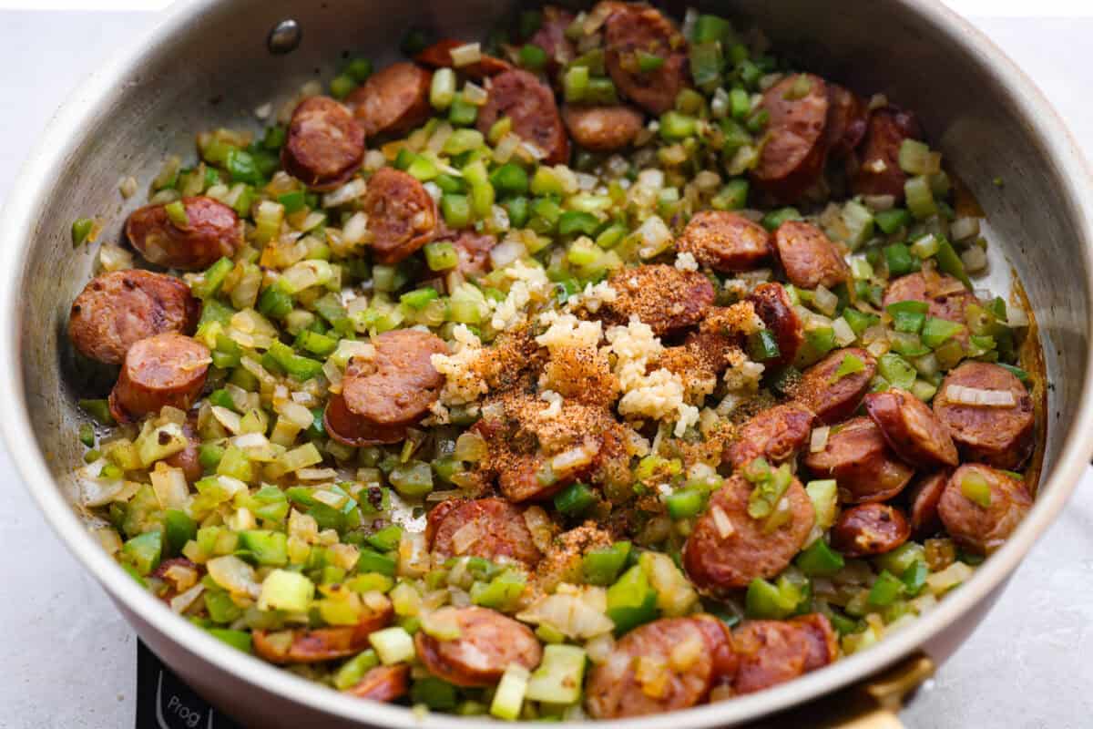 If your family is hungry now and you don't have time to soak beans or babysit the stove, this red beans and rice is for you. It is quick, cozy, and made with canned beans and smoky sausage. It tastes great and is ready fast! Peppers, onion, garlic and seasonings added to the skillet.