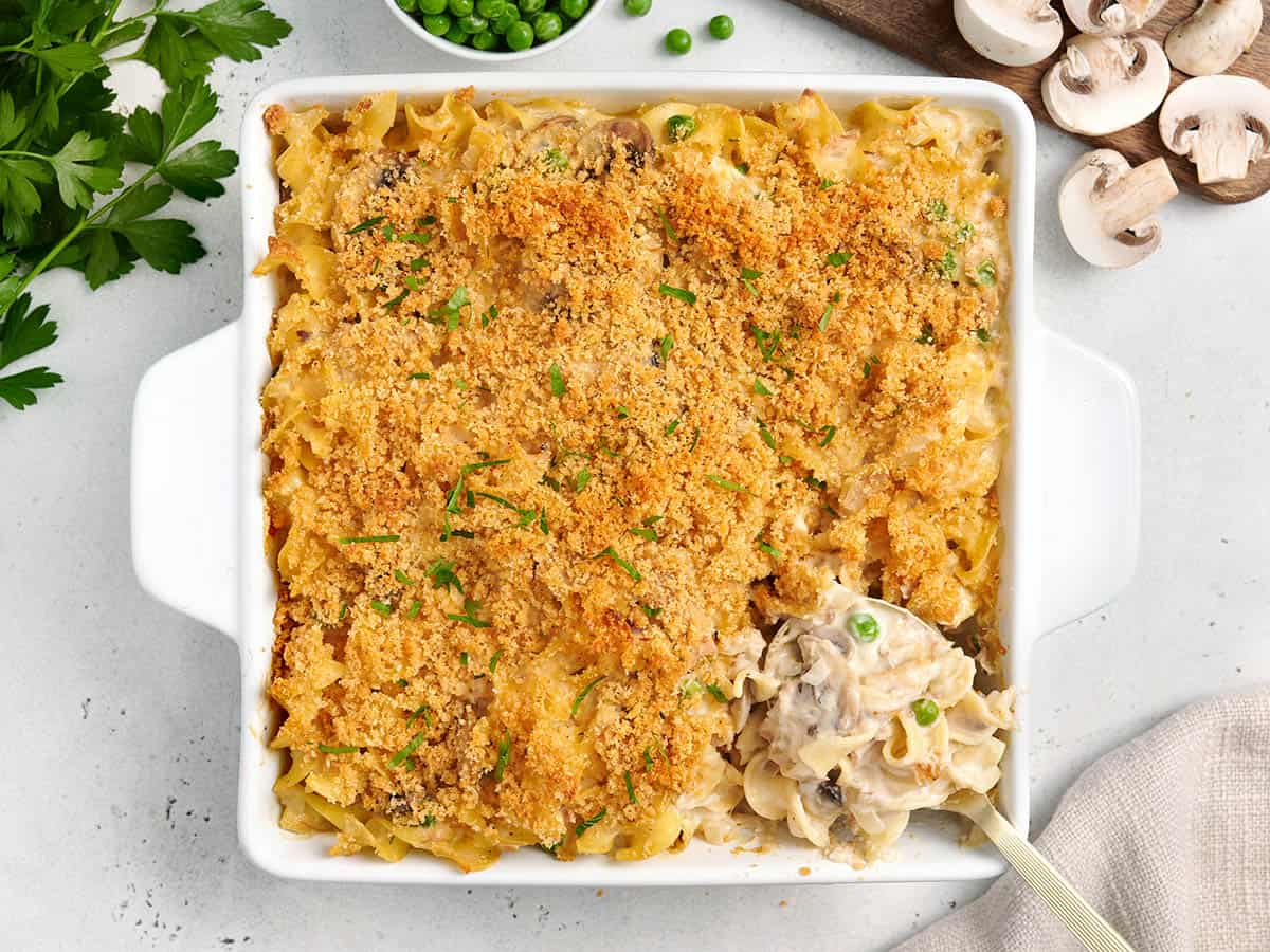 Overhead view of tuna noodle casserole in a casserole dish with a serving spoon.
