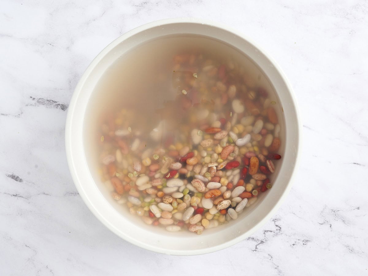 15 bean soup mix soaking in a bowl of water.