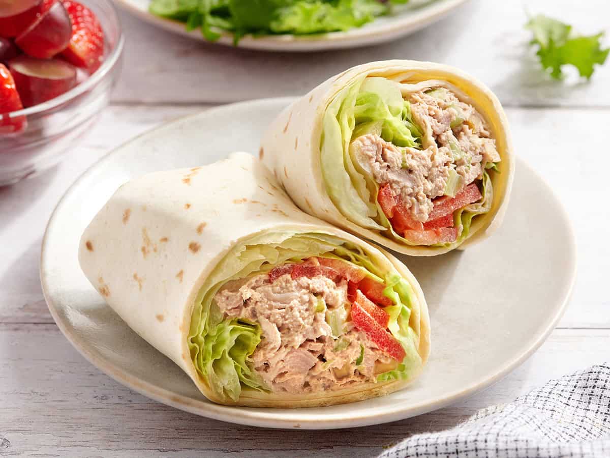 A tuna wrap sliced in half on a plate.