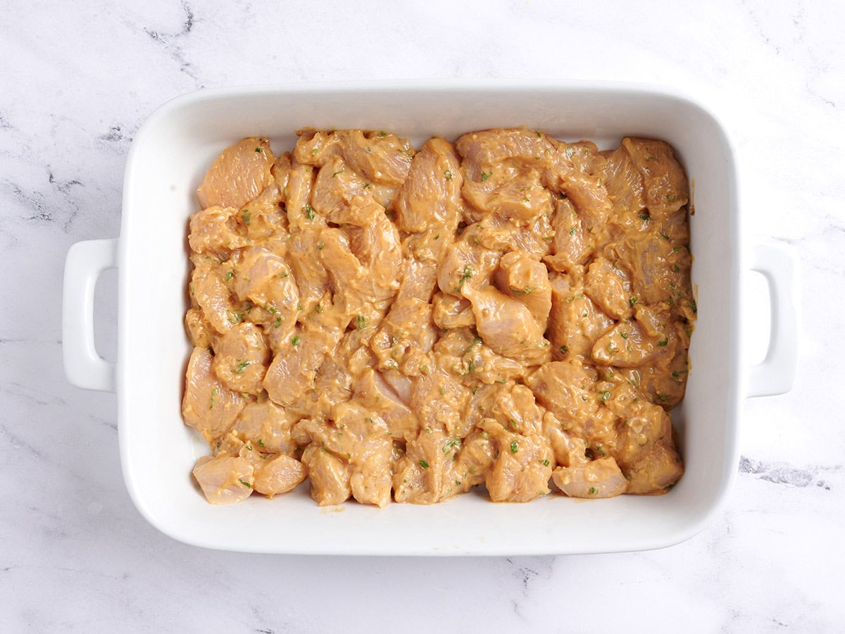 Marinated chicken in a baking dish.
