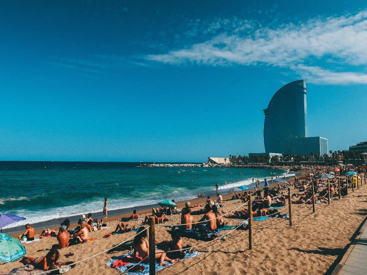 people enjoying the beach and ocean along the coast of barcelona