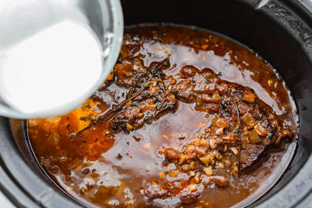Cornstarch slurry added to the slow cooker to help thicken the sauce.