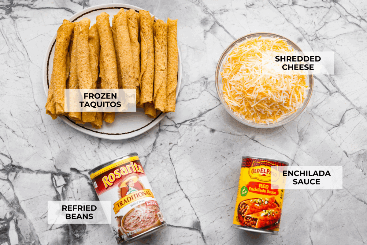 When you want enchiladas without the work, these Lazy Enchiladas are it! Four ingredients. Less than 30 minutes. Just layer frozen taquitos with beans, sauce, and cheese, bake until bubbly, and boom, dinner is served! Overhead shot of labeled lazy enchiladas ingredients.