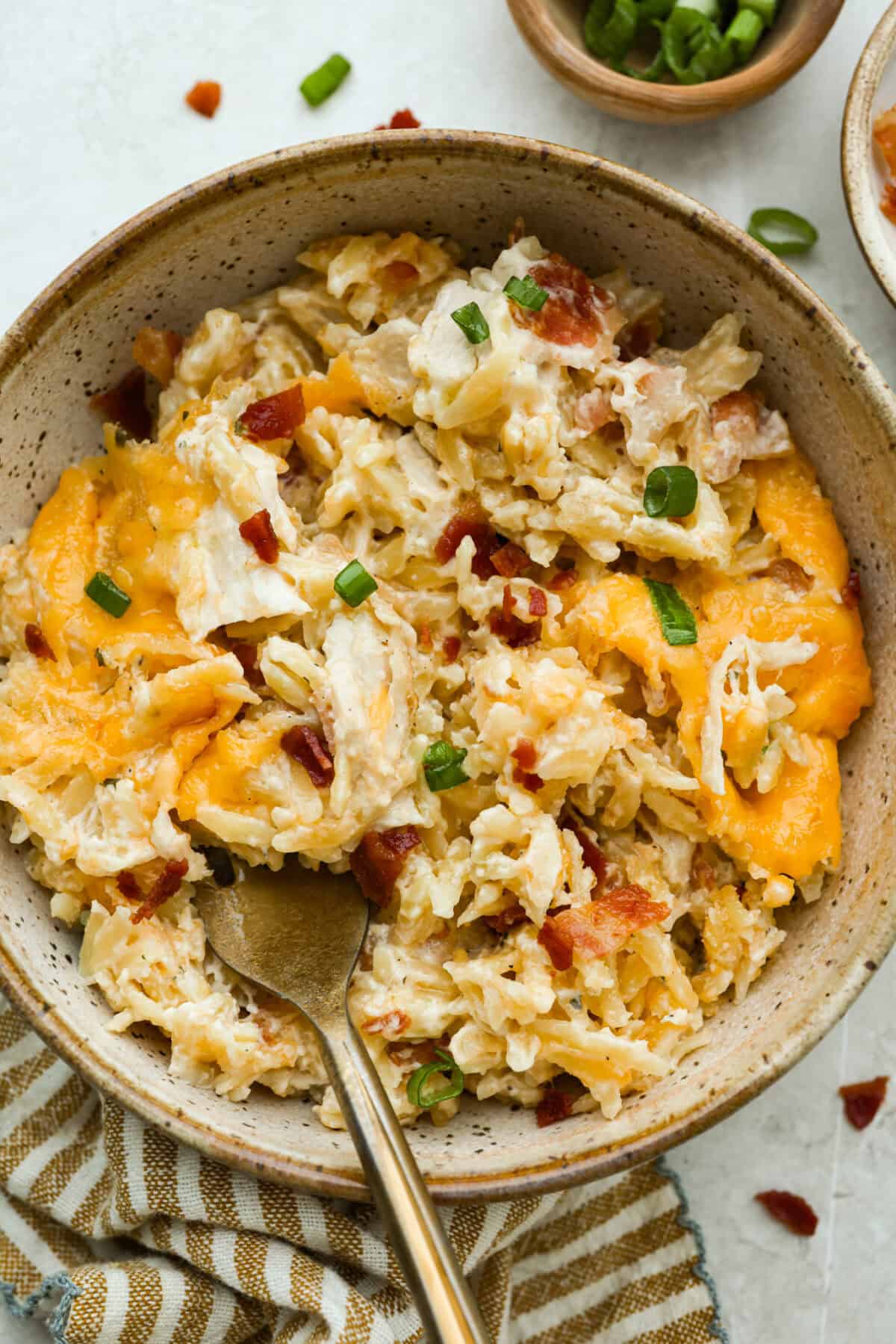 Bowl of crack chicken orzo with a gold spoon.