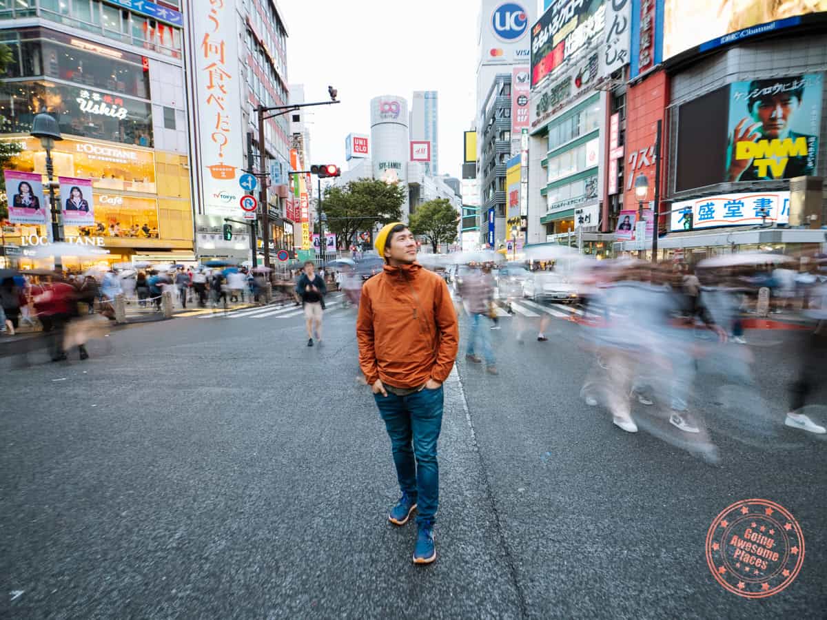 shinjuku crossing in tokyo with blurred motion surrounding while will is standing still