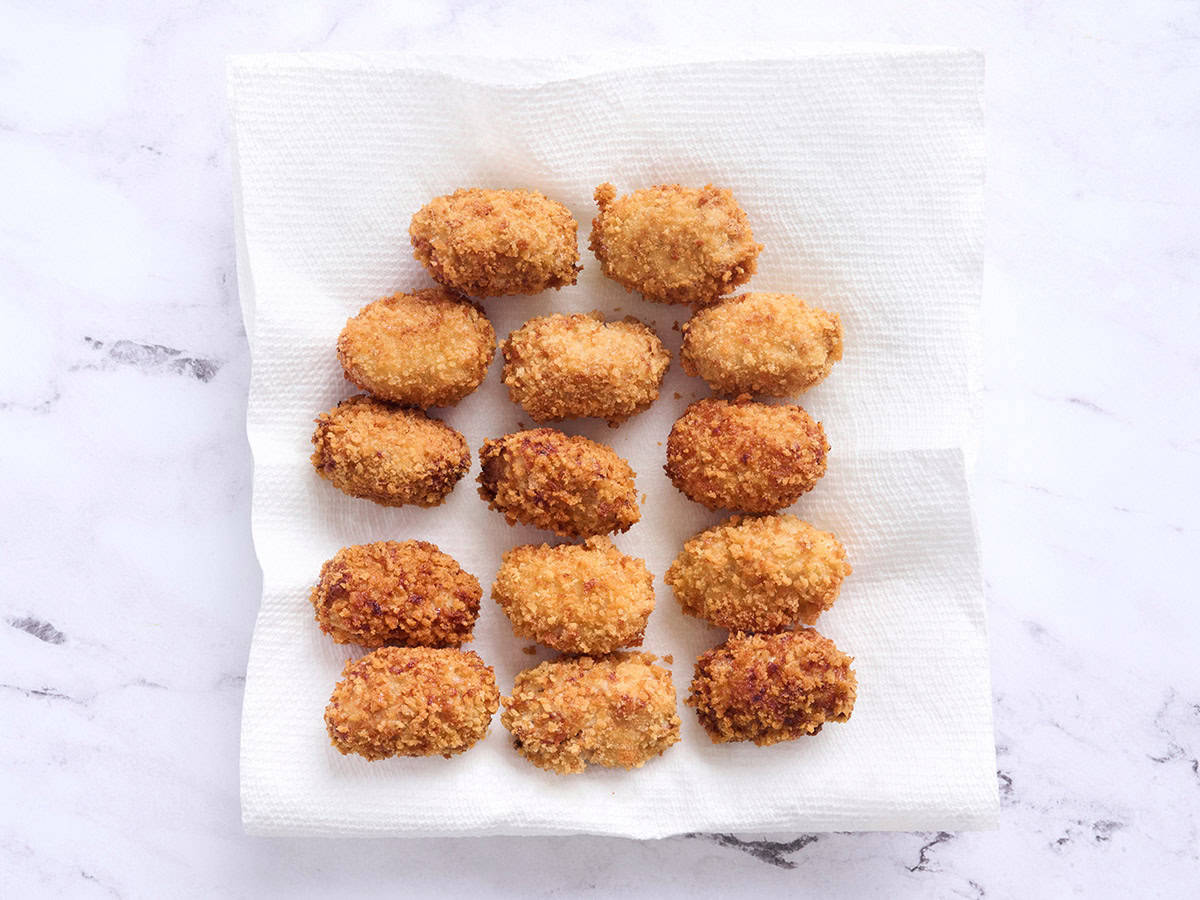 Finished chicken croquettes on a paper towel.