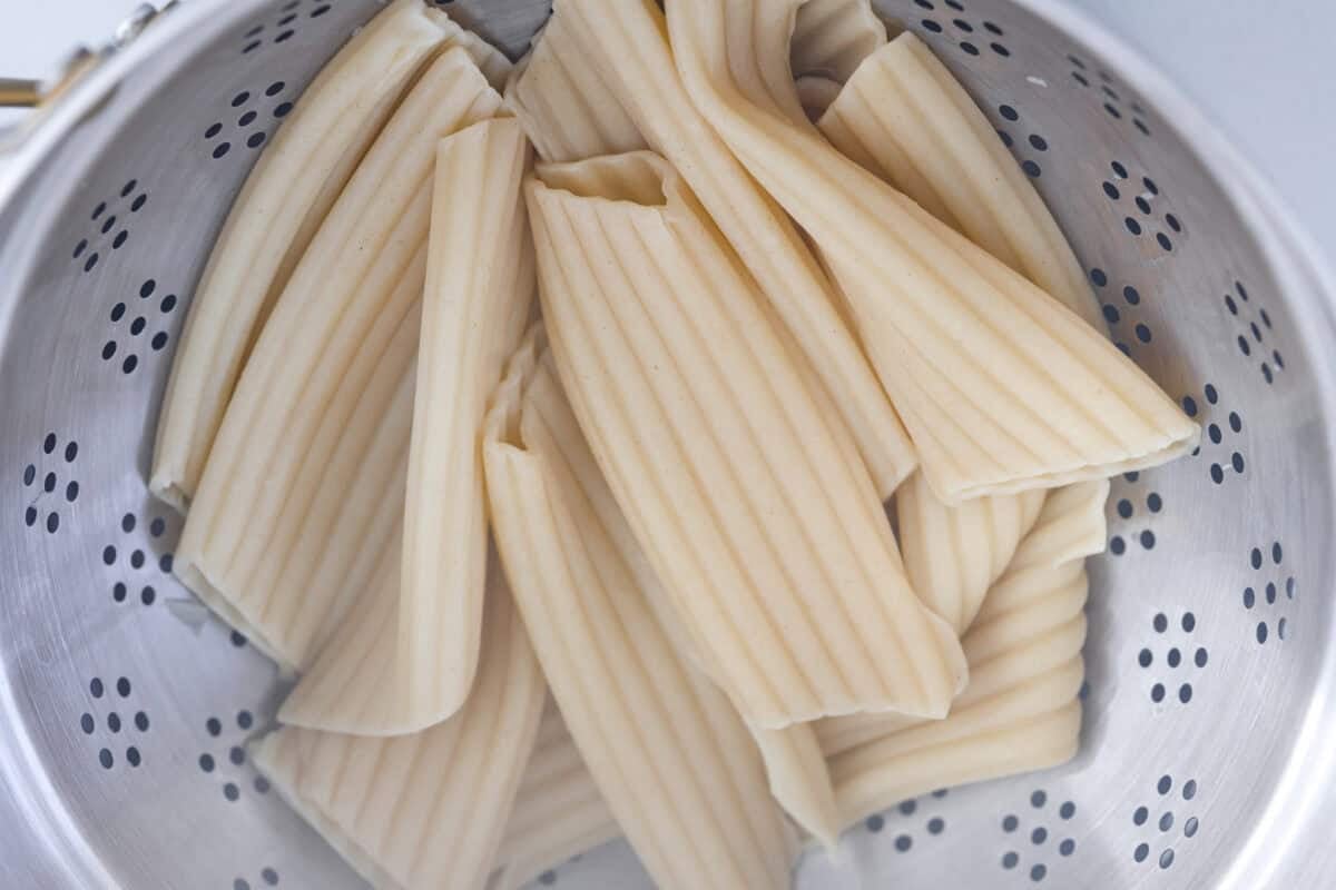 Manicotti pasta noodles cooked and in a colander.
