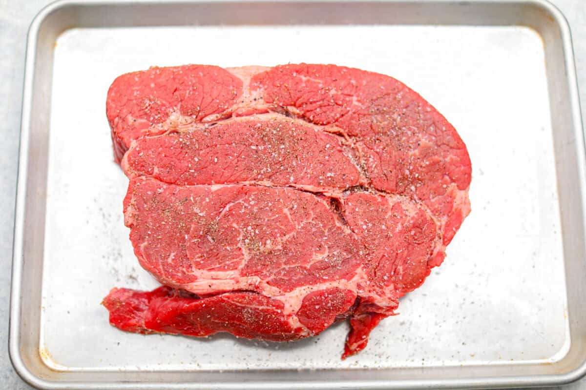 Meat seasoned and sitting on a cookie sheet ready to be browned.