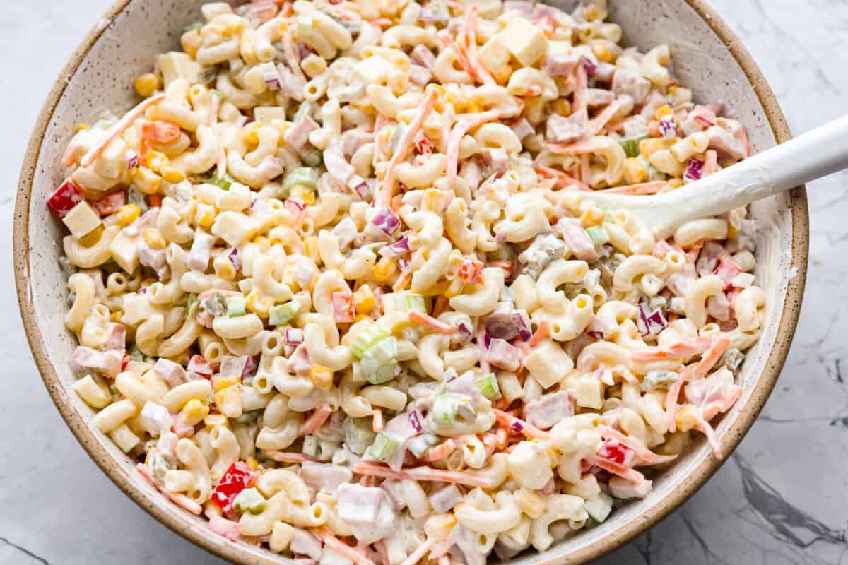 This Mexican macaroni salad is a fun twist on a classic! It’s creamy, tangy, and full of flavor with crisp veggies, cheese, and a little kick from jalapeños. Perfect for BBQs, potlucks, or anytime you want an easy, delicious side. Mexican macaroni salad ingredients all mixed together with the dressing.
