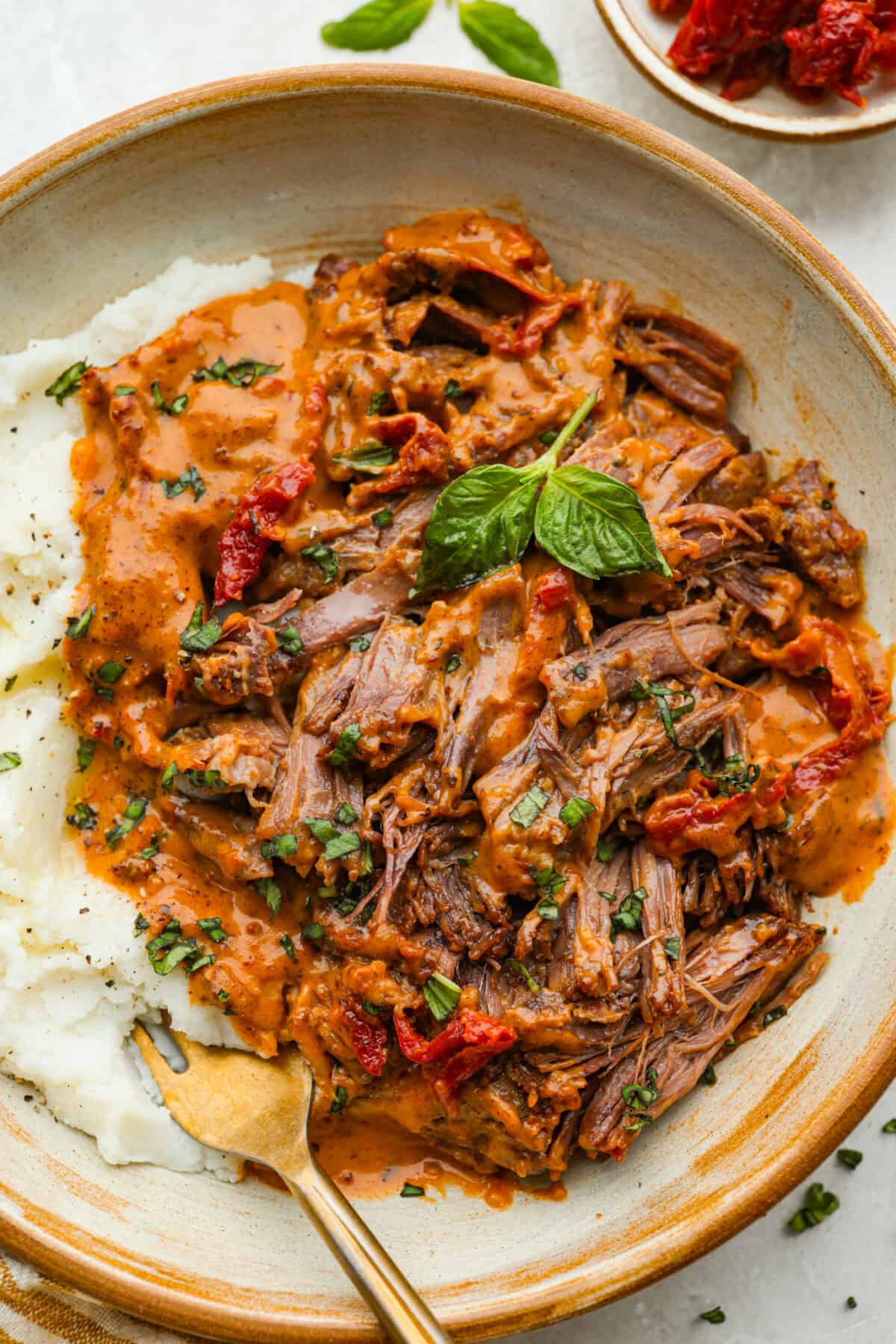 Plated marry me pot roast with some mashed potatoes.