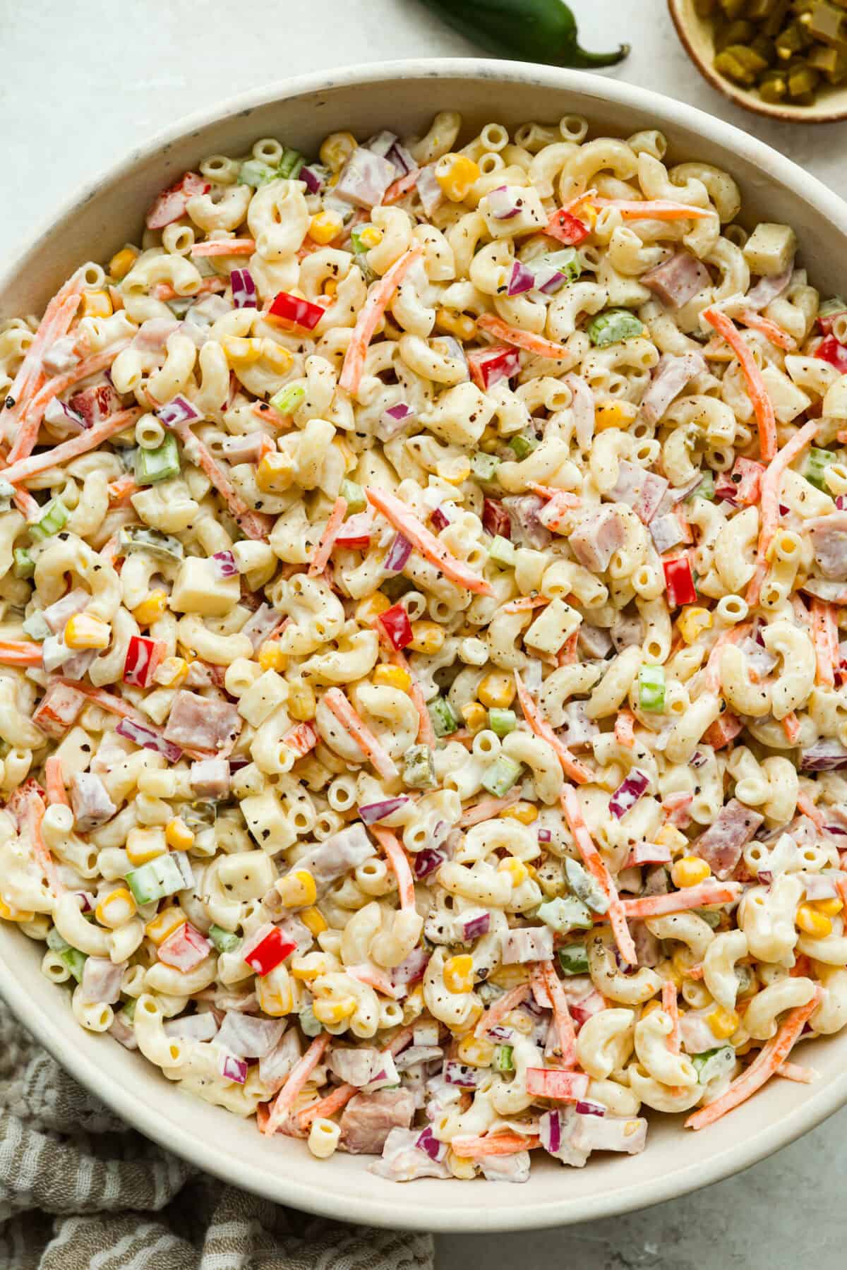 This Mexican macaroni salad is a fun twist on a classic! It’s creamy, tangy, and full of flavor with crisp veggies, cheese, and a little kick from jalapeños. Perfect for BBQs, potlucks, or anytime you want an easy, delicious side. Large bowl of Mexican macaroni salad.