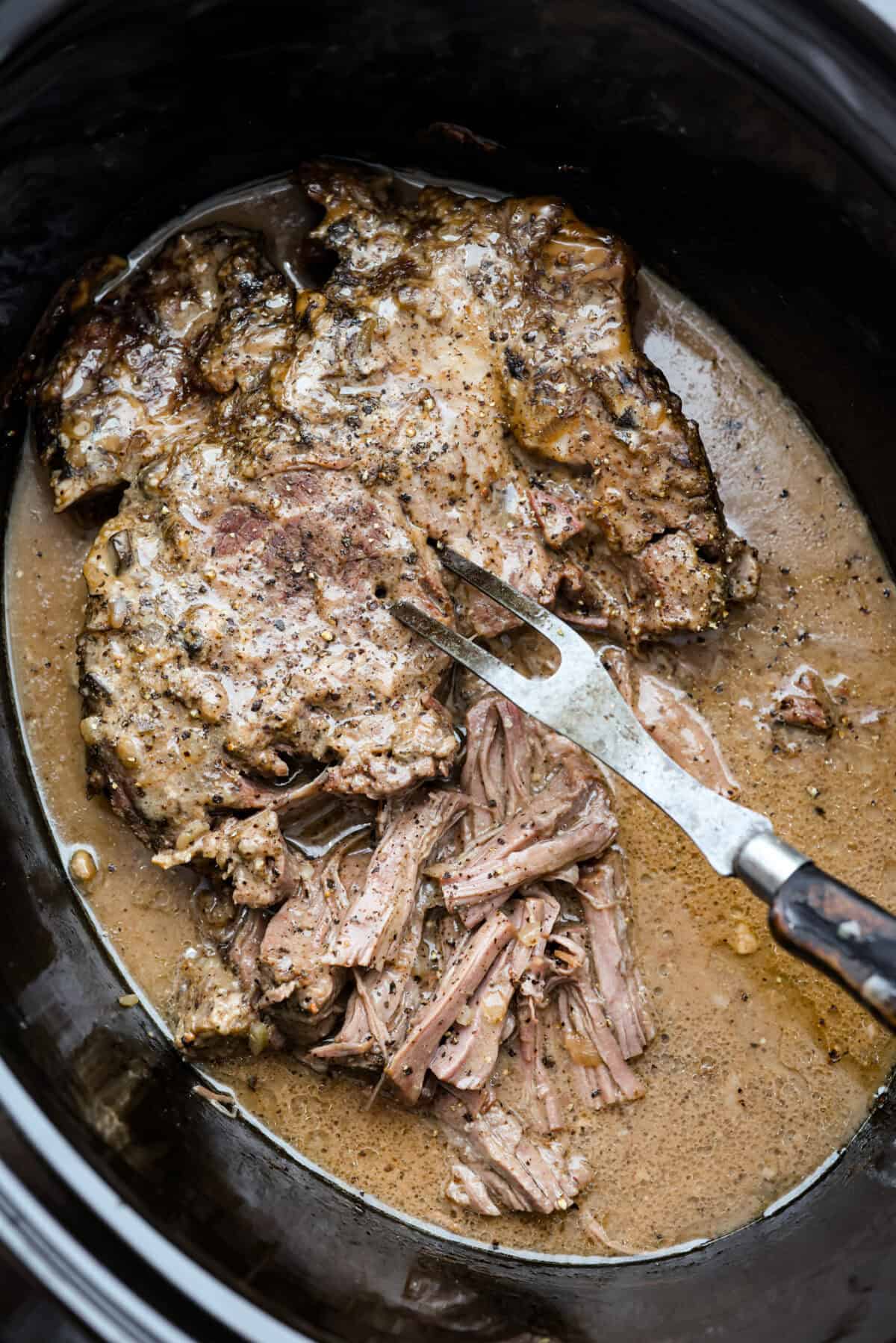 Large, cooked, 4 ingredient mushroom beef in a crockpot.