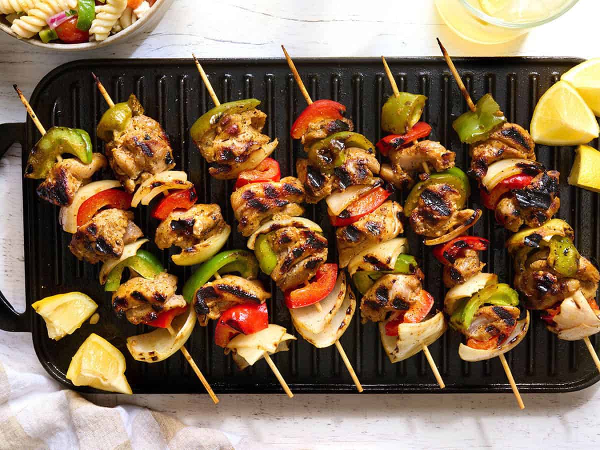 Overhead view of chicken kabobs on a grill.