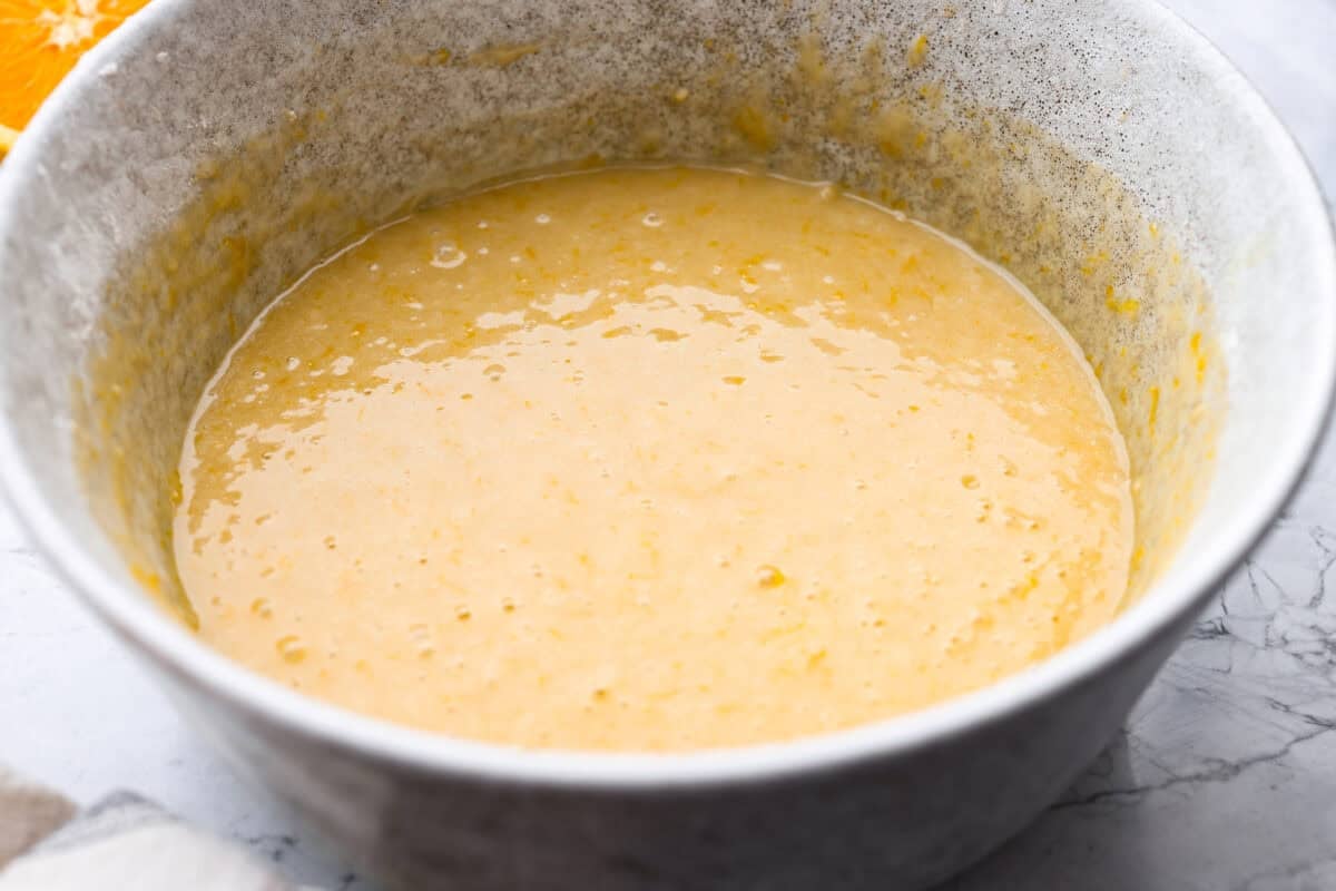 Wet and dry ingredients combined in a mixing bowl.