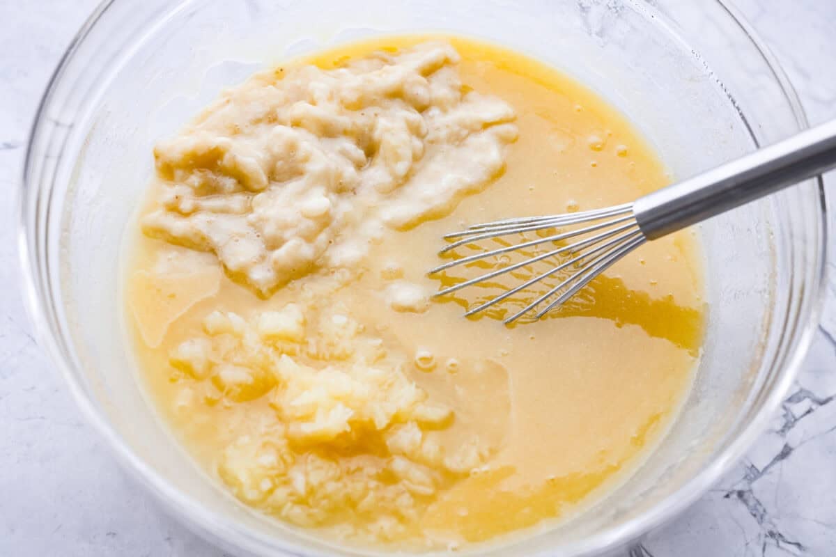 Wet ingredients added to a mixing bowl ready to be whisked together.
