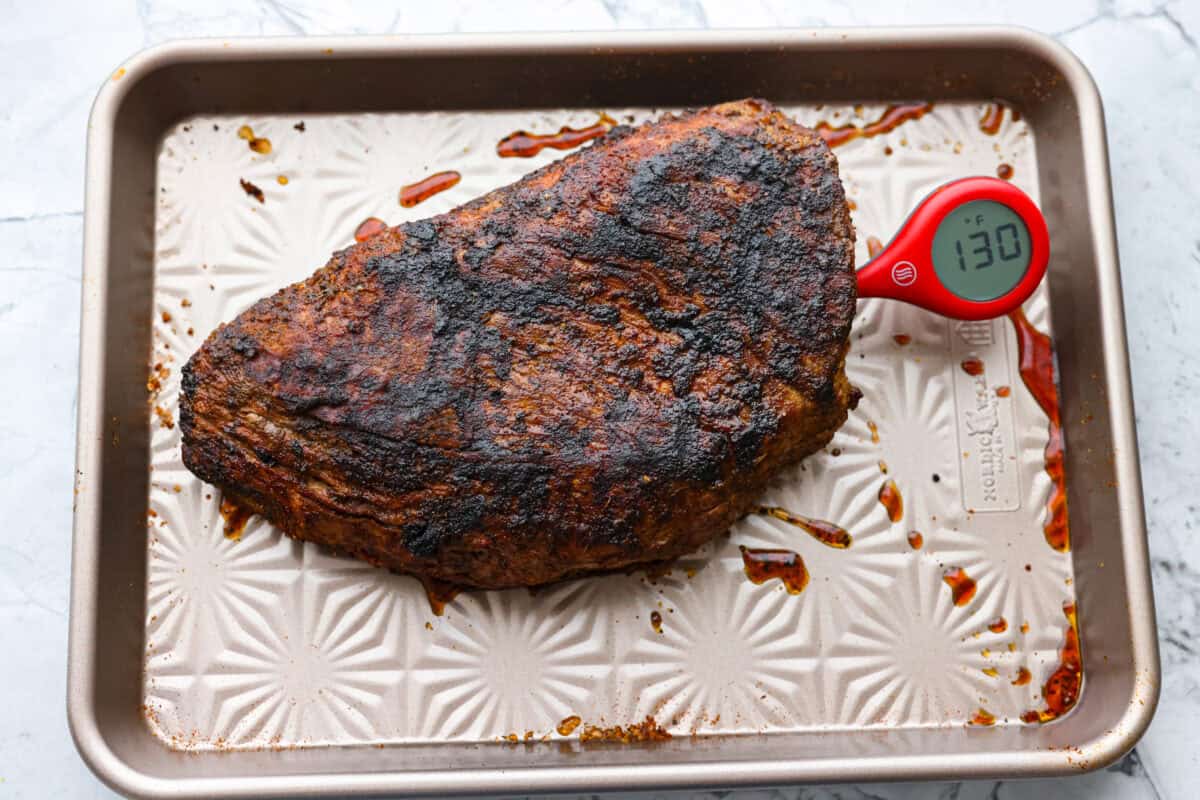 Instant read thermometer checking the temperature of the cooked meat.
