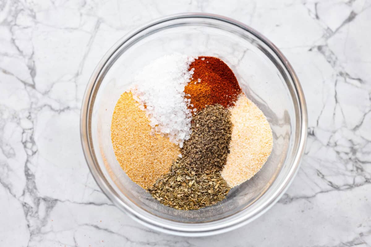 All of the seasonings and spices added to a bowl.