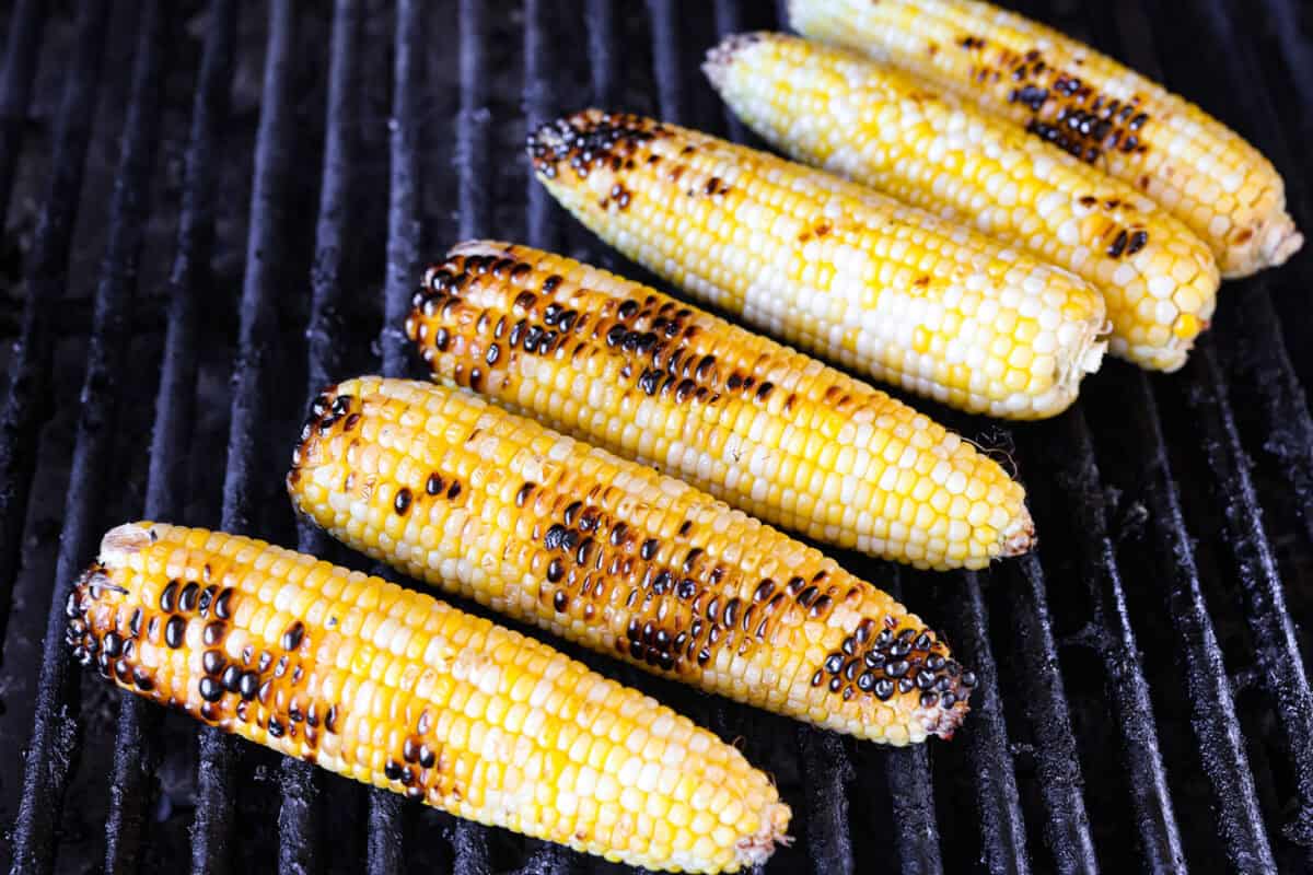 6 ears of corn on a hot grill.