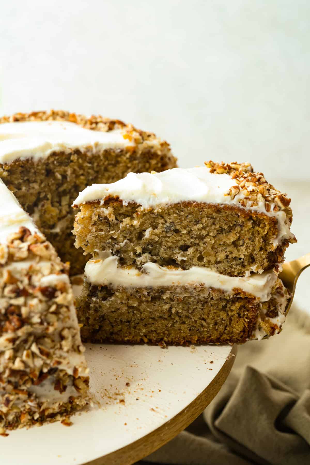 Slice of hummingbird cake being taken out of the cake.