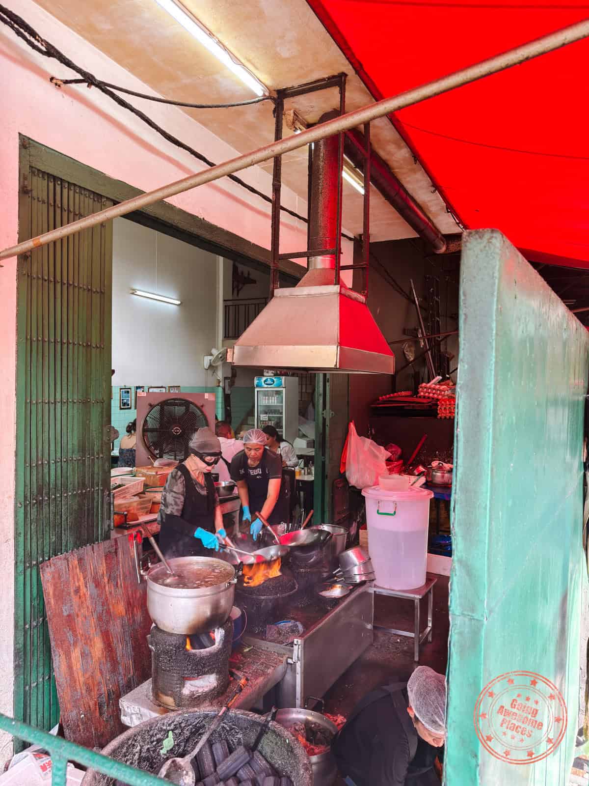jay fai with goggles cooking at her restaurant