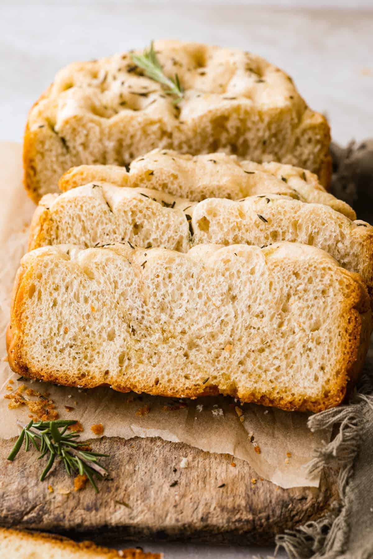 Sliced slow cooker focaccia bread on a cutting board.