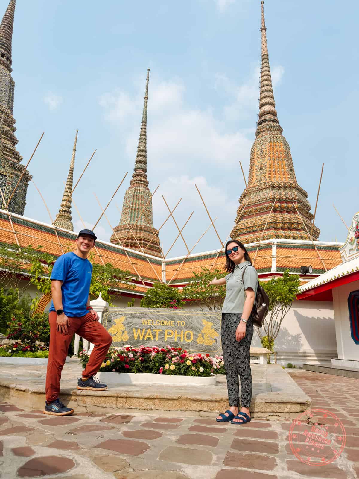 will and chantelle standing by wat pho sign