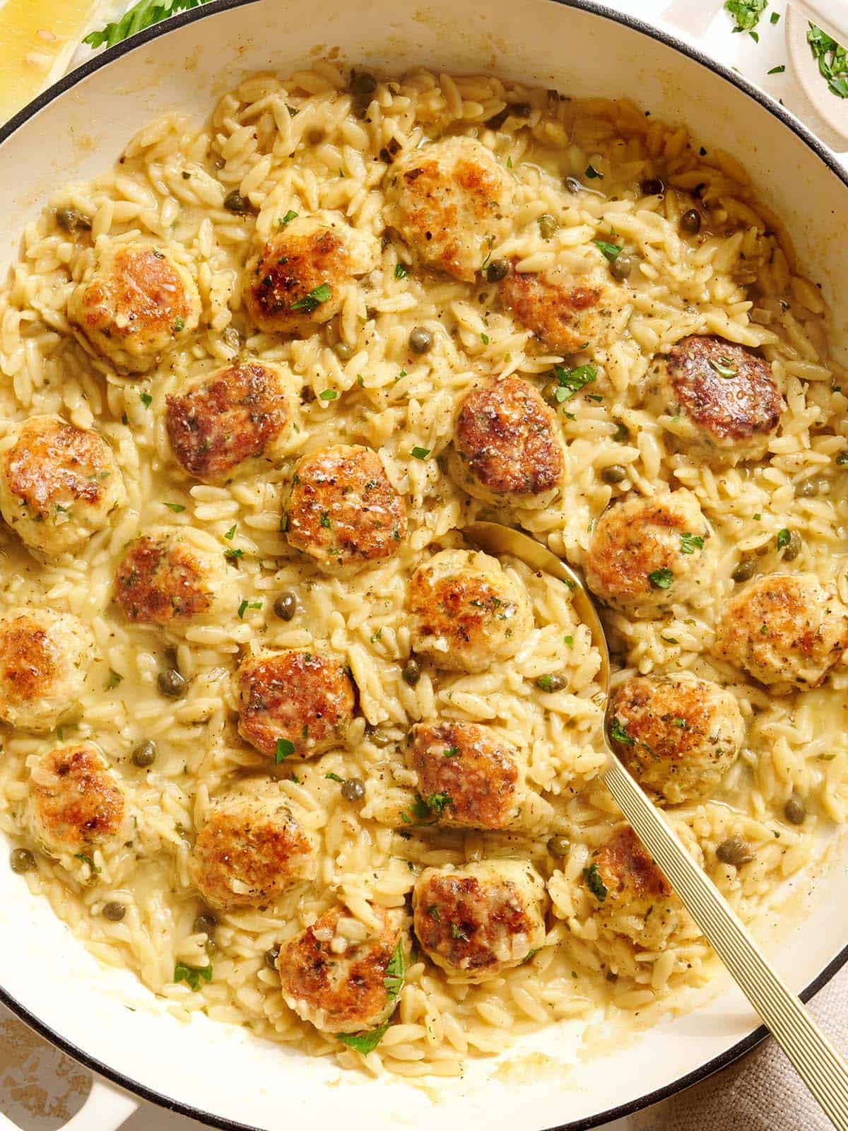 Overhead view of a chicken piccata meatball and orzo skillet.