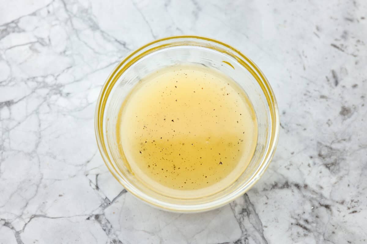 All of the dressing ingredients added to a bowl and whisked together.