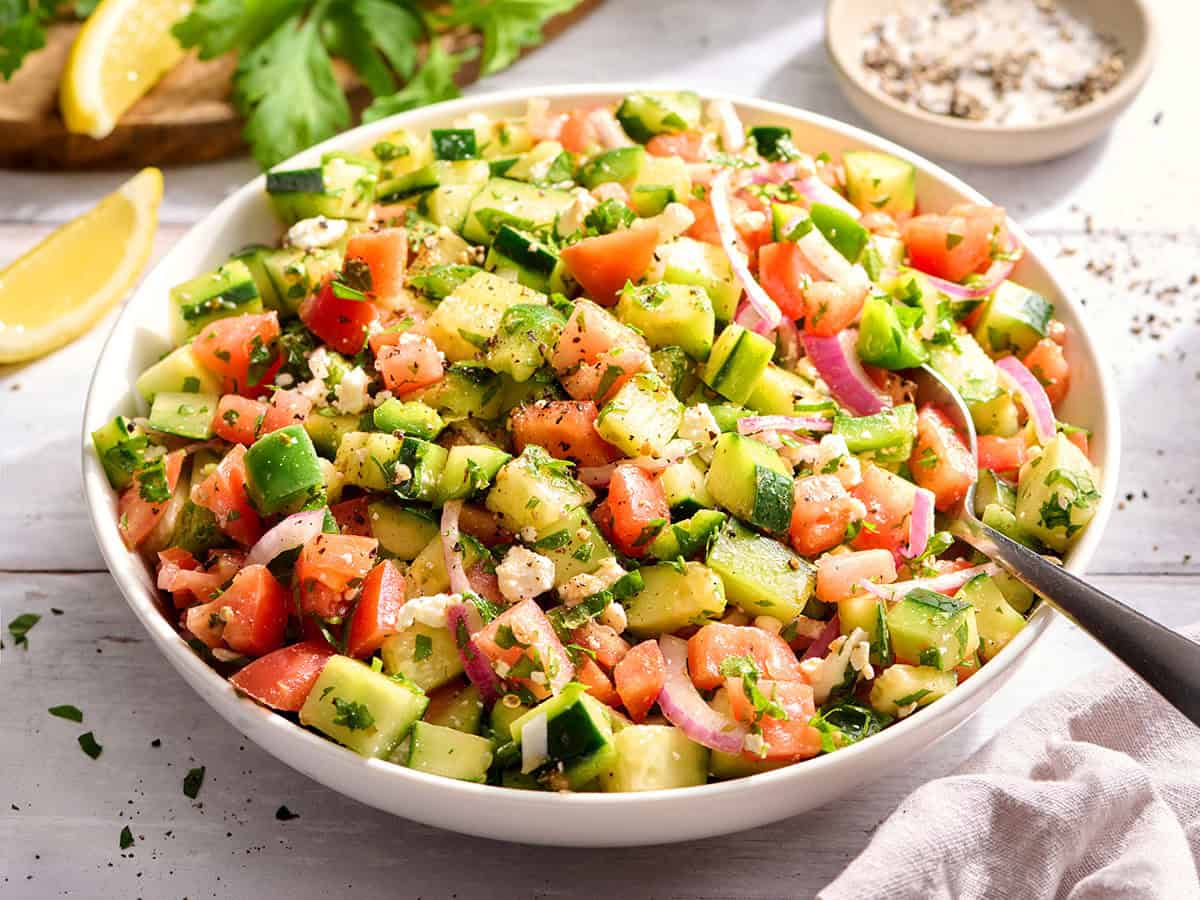 Front view of a fresh cucumber tomato salad in a bowl.