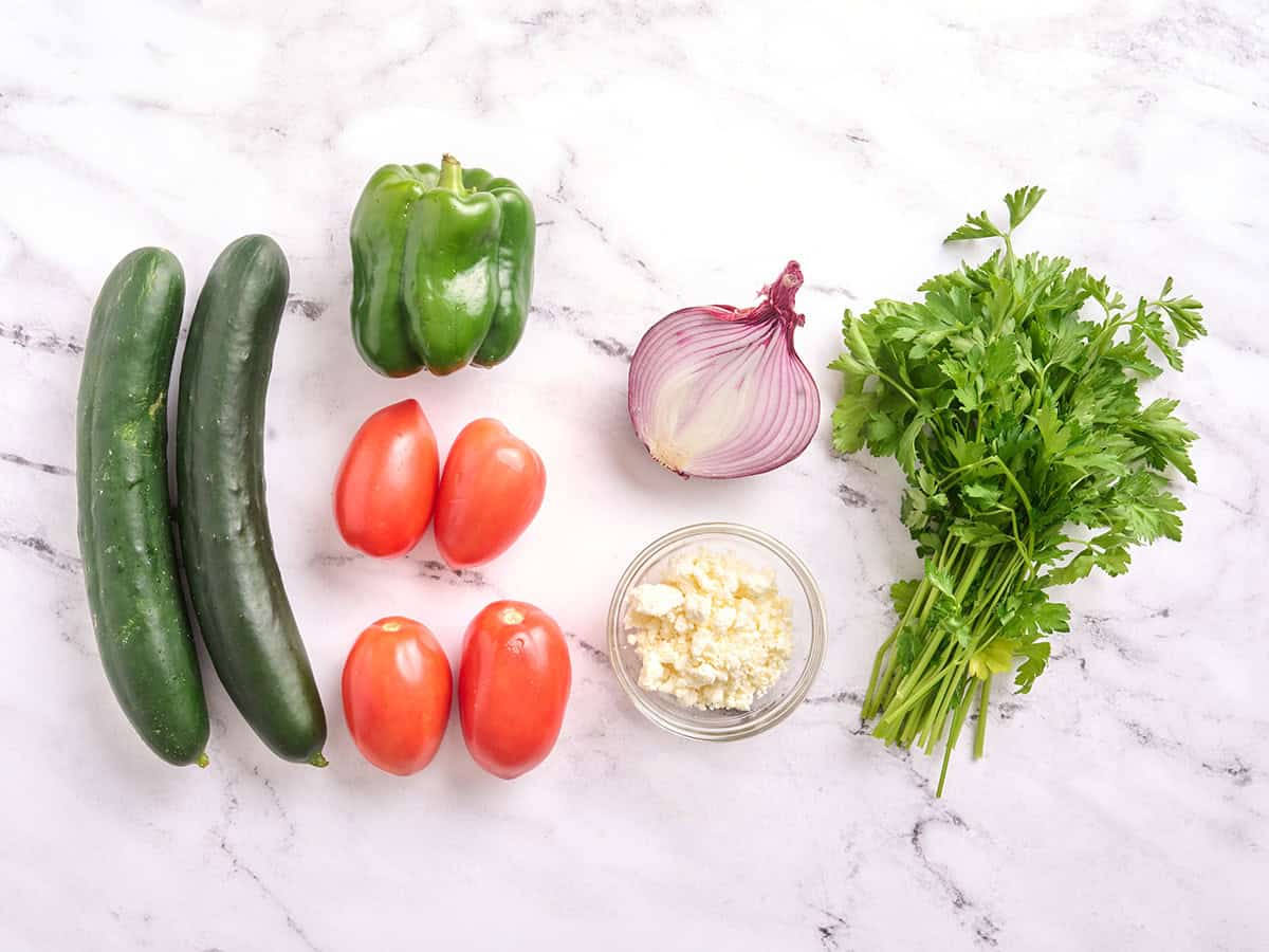 The fresh ingredients to make a cucumber tomato salad.