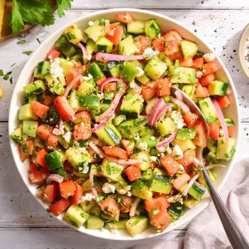 Overhead view of a bowl of cucumber tomato salad.