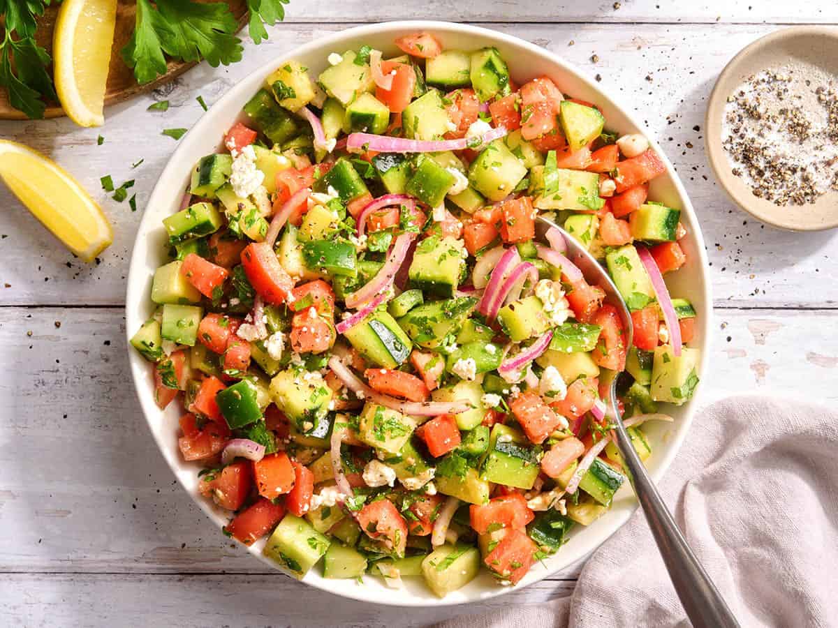 Overhead view of a bowl of cucumber tomato salad.