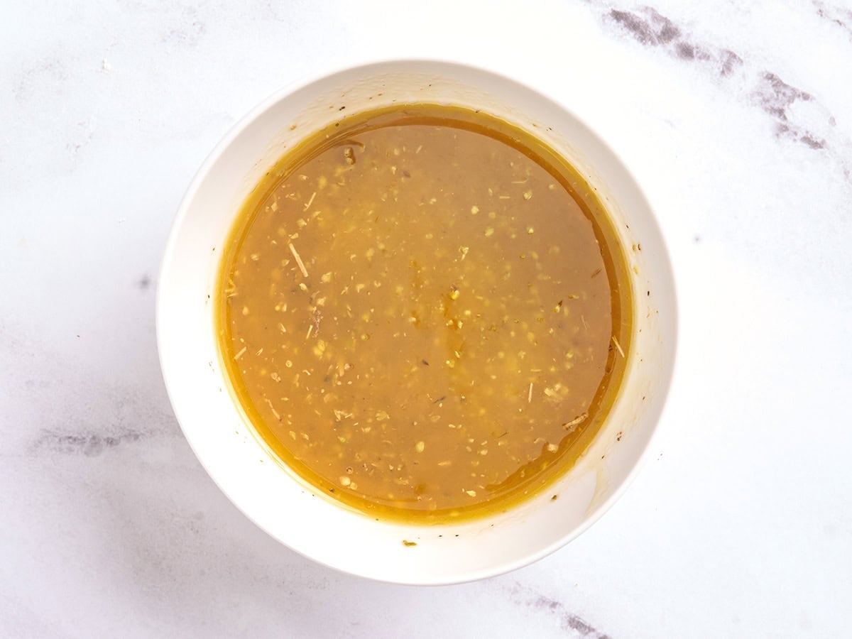 Combined dressing for cucumber tomato salad in a bowl.