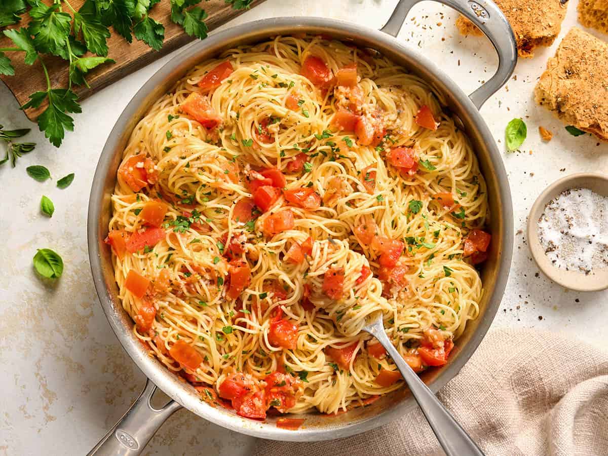 Overhead view of a pot of angel hair pasta pomodoro with a fork.